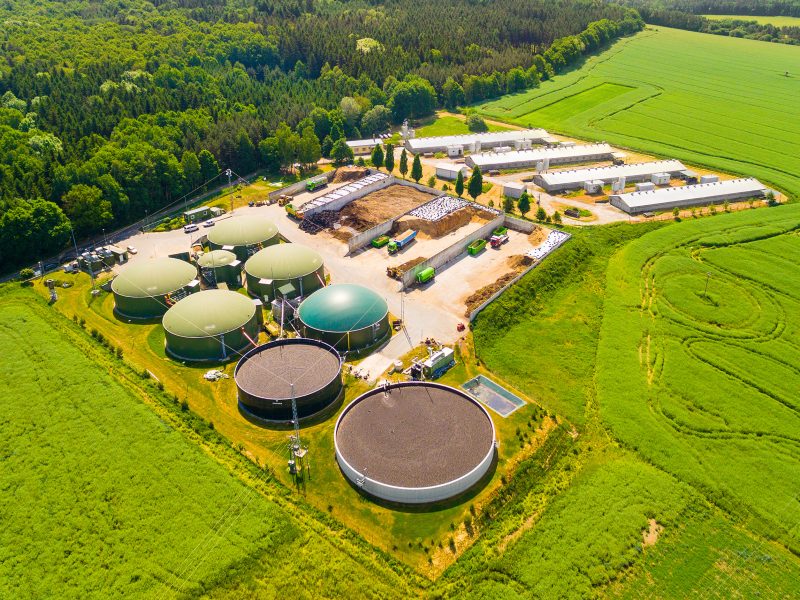 Aerial view over biogas plant and farm in green fields. Renewable energy from biomass. Modern agriculture in Czech Republic and European Union.